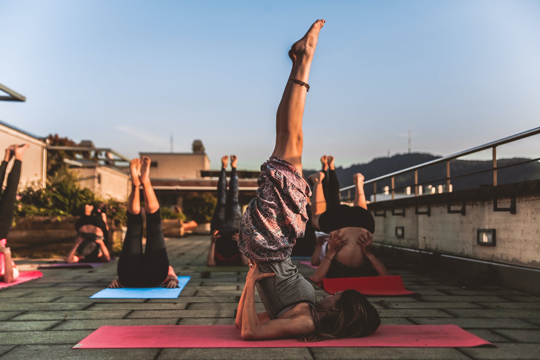 group of women lying on yoga mat under blue sky