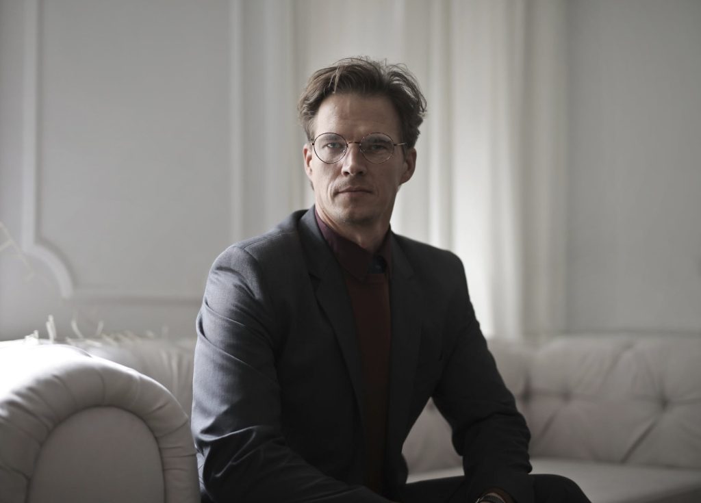 well dressed businessman sitting on sofa with a good posture