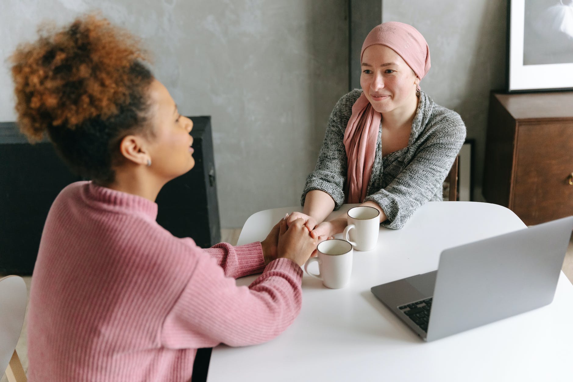 a woman holding her hands with her friend: cancer prevention medicine