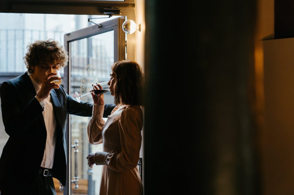 woman in white coat holding black smartphone