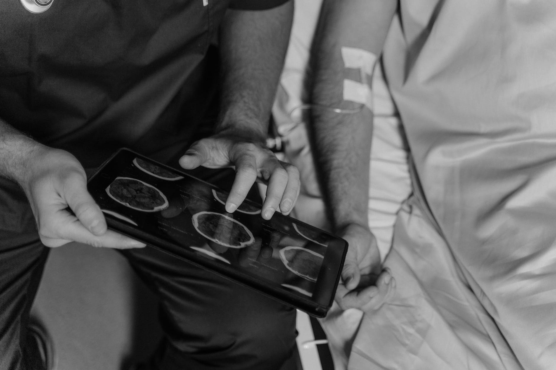 grayscale photo of a doctor using a digital tablet