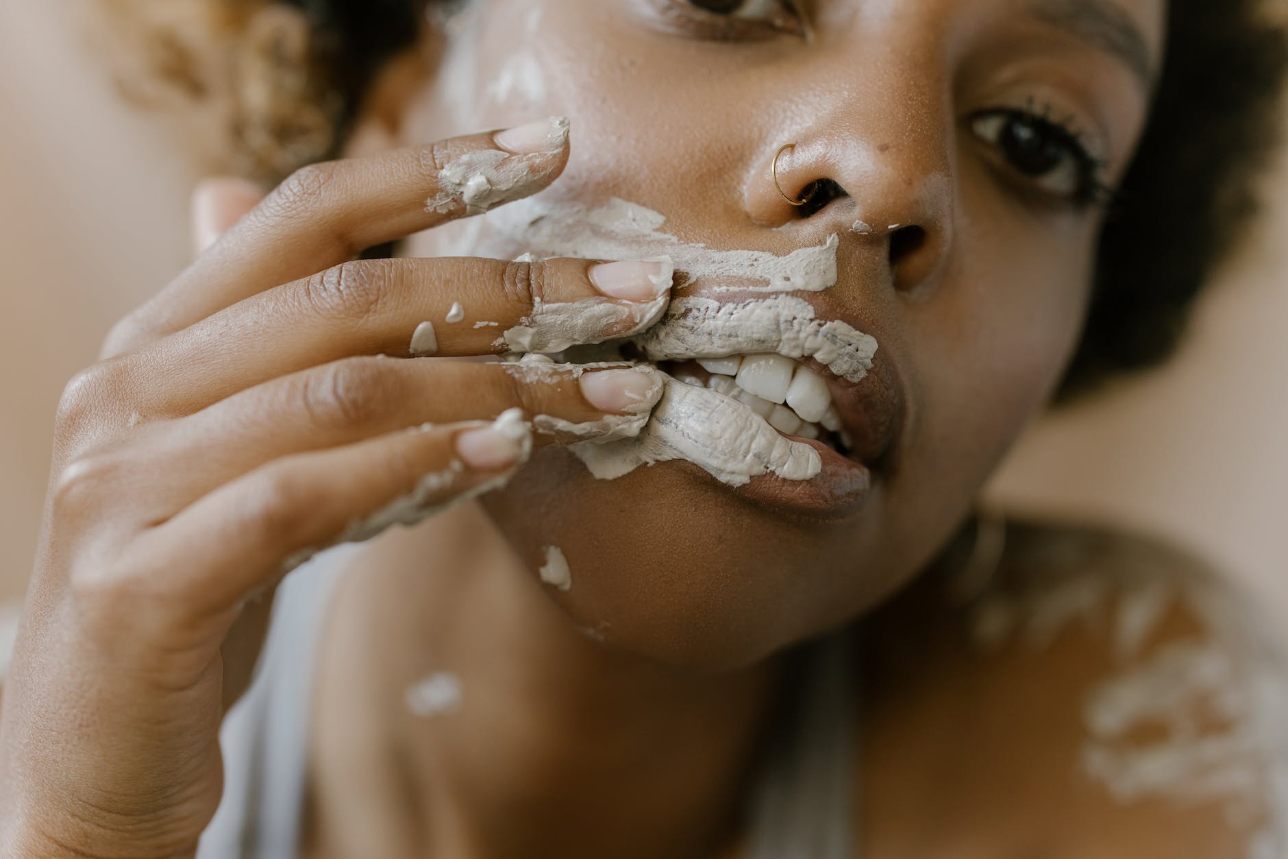 woman applying clay mask on face