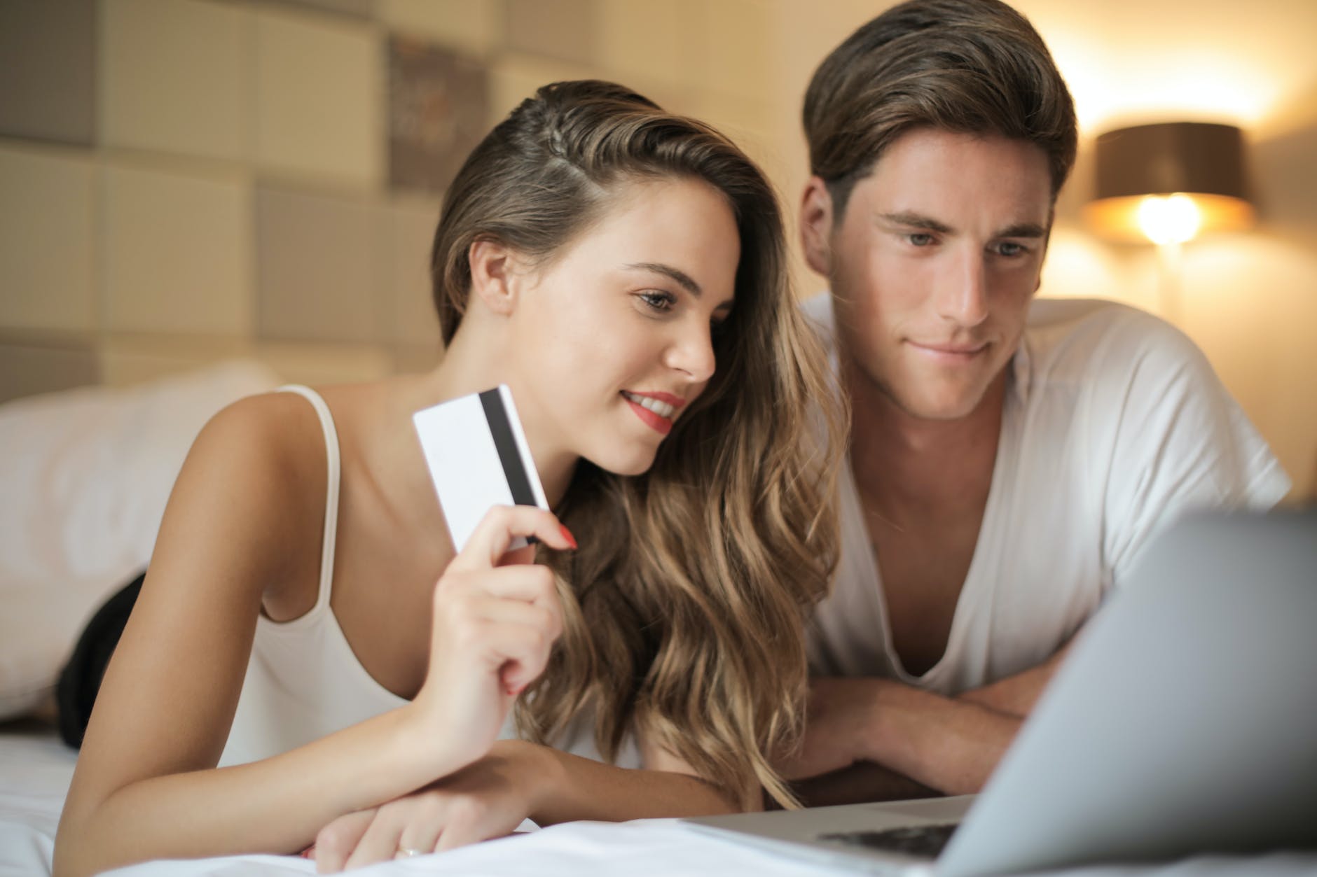 cheerful couple making online purchases at home: Virtual Date Ideas