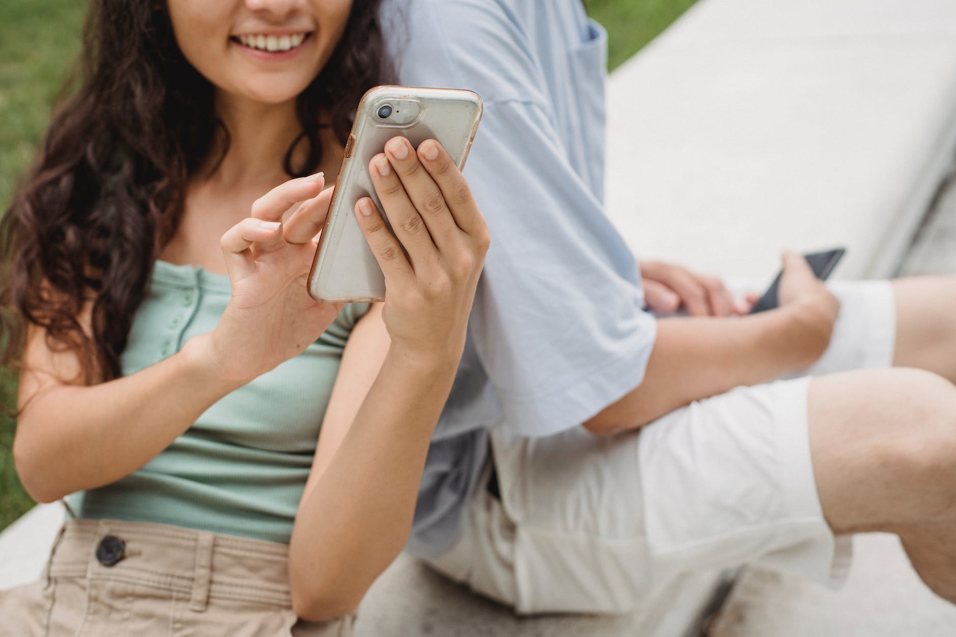 crop smiling woman surfing internet on smartphone near boyfriend