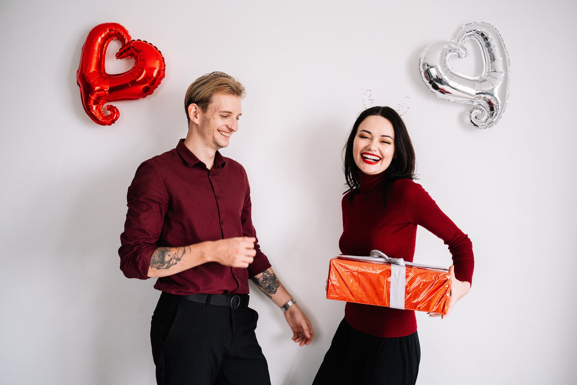 a woman giving a man a gift: Long-Distance Valentine's Day Gifts