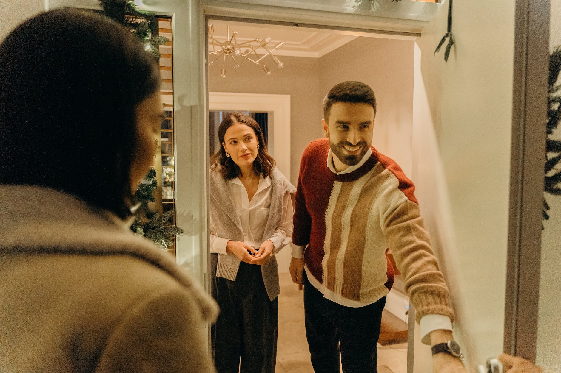 a smiling man opening the door